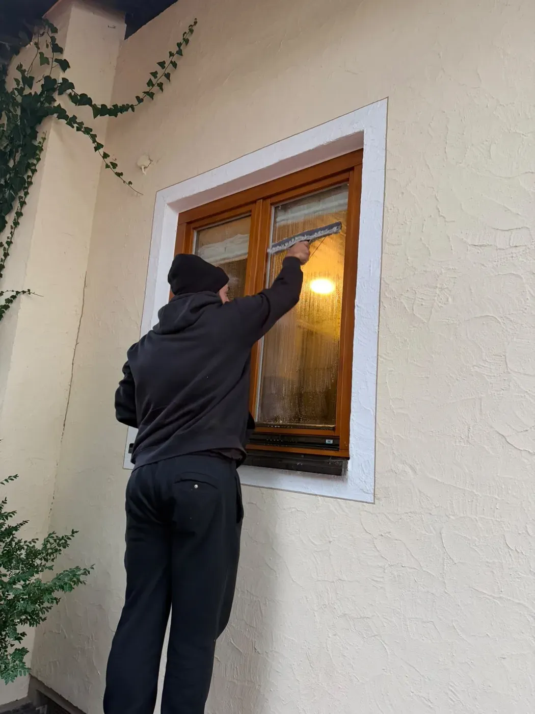 Mitarbeiter von Modus zieht ein zweiflügeliges Holzfenster von außen mit dem Fensterabzieher ab